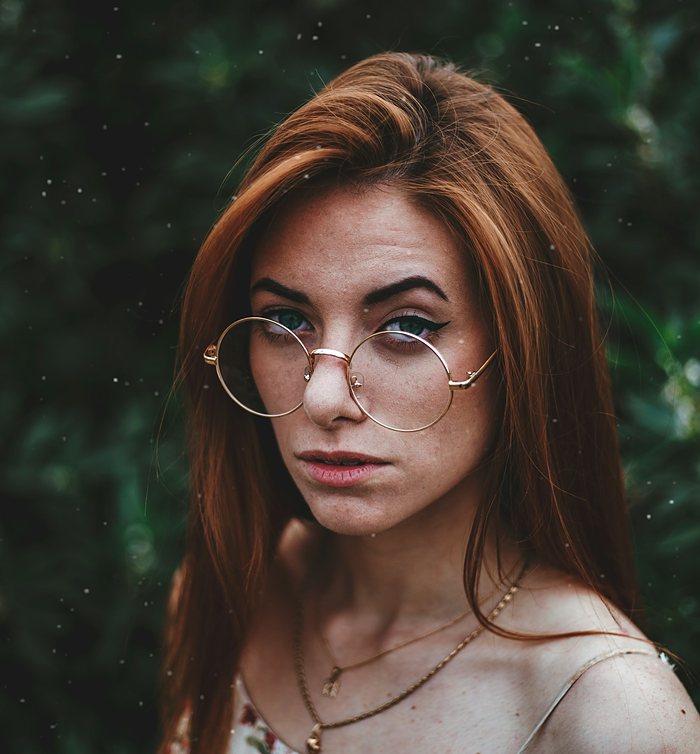 Melena cobriza con gafas redondas de metal
